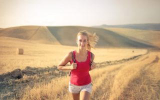 A woman jogging through vast, golden wheat fields under the summer sun, symbolizing freedom and adventure.