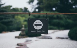 Peaceful garden scene with 'Do Not Enter' sign, promoting serenity and exclusivity.